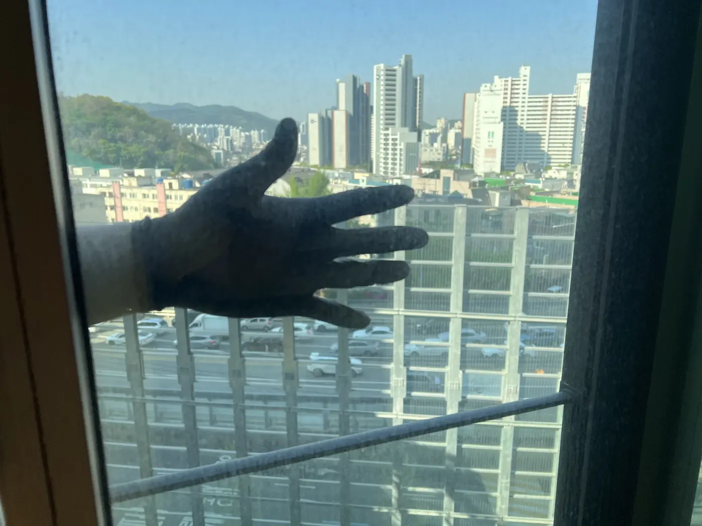경기아파트유리창청소 작업 전 거실 유리와 도로변 풍경 사진